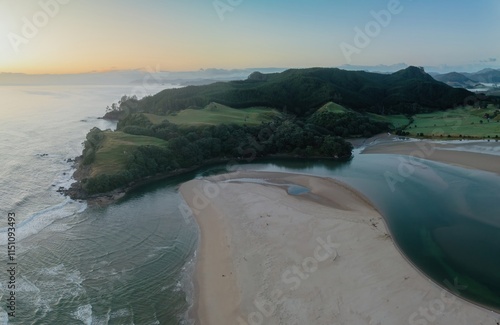 Coastal estuary at dawn, tranquil scene. Ocean meets the land, showcasing a serene bay. OPOUTERE, COROMANDEL PENINSULA, NEW ZEALAND photo