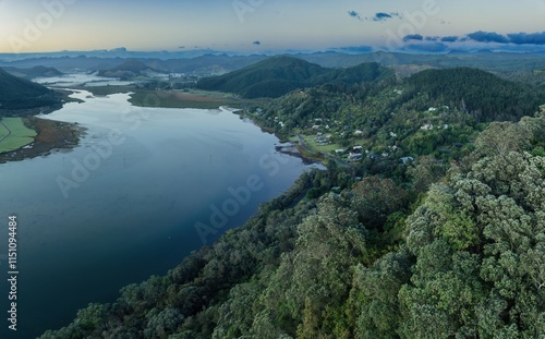 Misty morning view of a New Zealand town nestled beside a river. Tranquil landscape. OPOUTERE, COROMANDEL PENINSULA, NEW ZEALAND photo