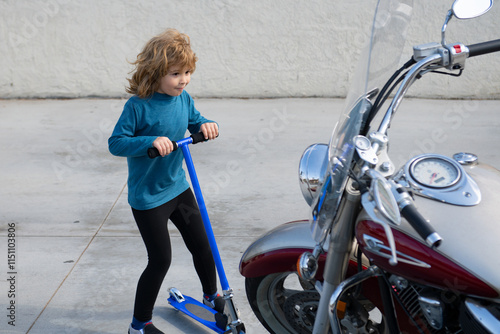 Kid future. The surprised child saw a big motorcycle outdoor. He dreams of riding. Child imagine concept. Kids dreams and inspiration. Kid dream. The boy imagines the road travel. photo