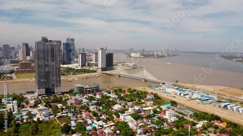 Aerial of Phnom Penh Bassac riverfront building construction and development with Downtown skyline buildings in view, Norea Bridge in view photo