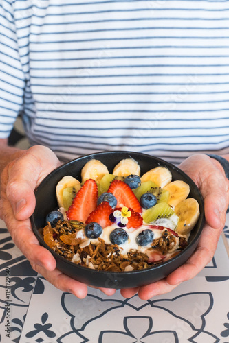 Man holding a granola bowl at a local cafe in Perth, Western Australia