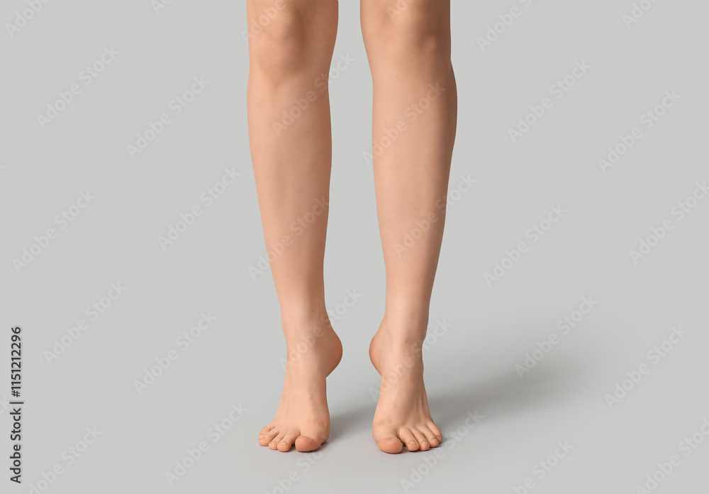 Legs of pretty young woman on grey background Legs of pretty young woman on grey background