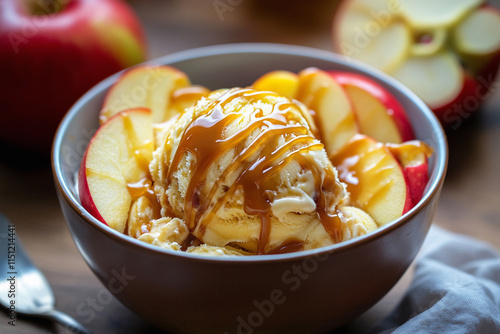 A cozy dessert scene with a bowl of caramel apple ice cream, topped with caramel drizzle and apple slices, warm and inviting photo