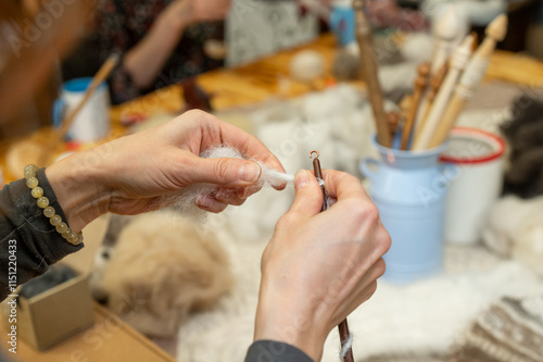 Caucasian female adult felting wool with craft tools at workshop table photo