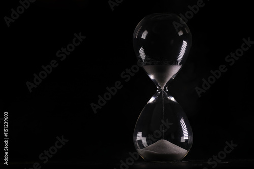 Elegant Hourglass Against Black Background, Time Concept with Sand Flowing in Glass Timer