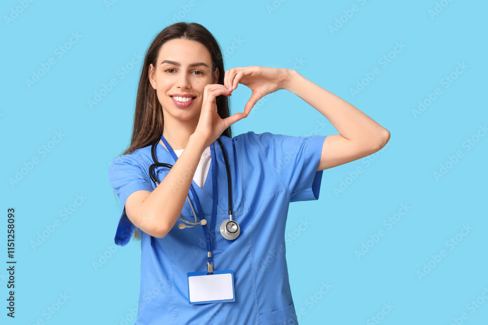 Young female doctor making heart gesture on blue background Young female doctor making heart gesture on blue background