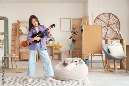 Teenage girl playing ukulel...