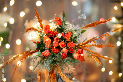 A bouquet of white and orange roses amidst bokeh lights