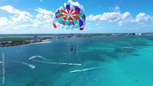 drone shot flying very close to a parachute on a sunny day with beautiful transparent and vivid blue water in cancun quintana roo