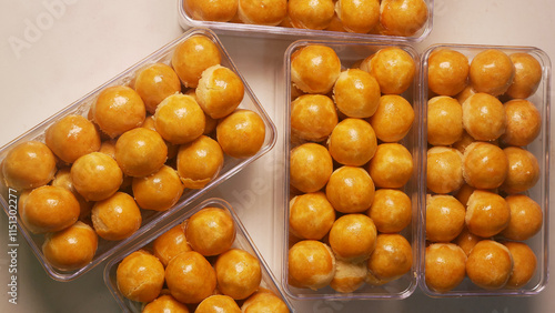 Nastar cookies with pineapple jam and glossy orange egg yolk spread, arranged in a plastic jar. is one of the traditional Indonesian cookies served during the celebration of Eid al-Fitr. photo