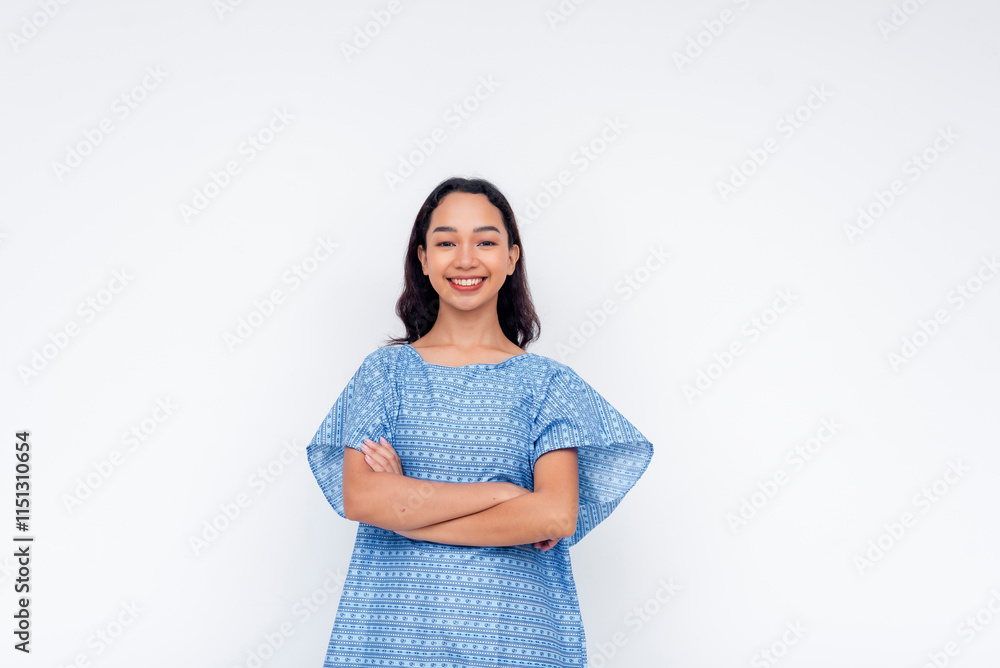 Portrait of a cheerful woman with folded arms wearing a patterned blue patient gown against a white background. Portrait of a cheerful woman with folded arms wearing a patterned blue patient gown against a white background.
