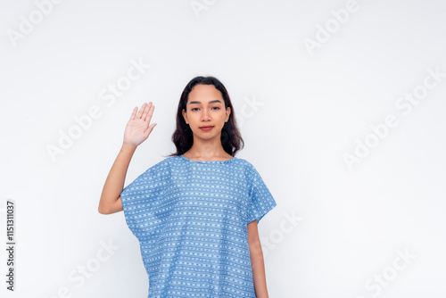 Young woman in a blue medical gown taking an oath gesture photo