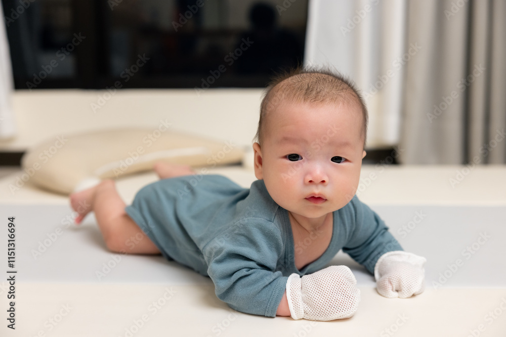Newborn baby wearing soft mittens at home Newborn baby wearing soft mittens at home