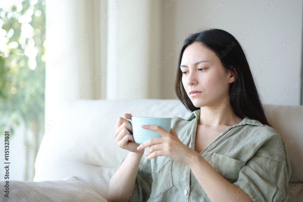 Apathetic asian woman drinking and complaining at home Apathetic asian woman drinking and complaining at home