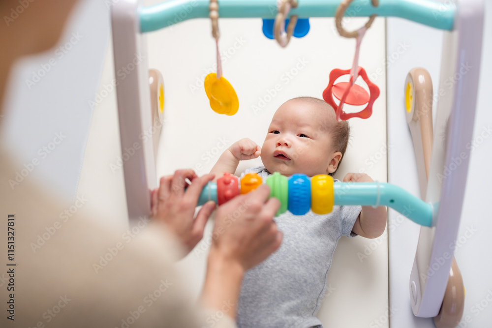 Mum playing with newborn baby and toy Mum playing with newborn baby and toy