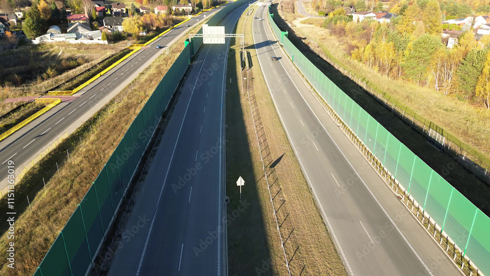 Top-down view of highway and green noise barriers Top-down view of highway and green noise barriers
