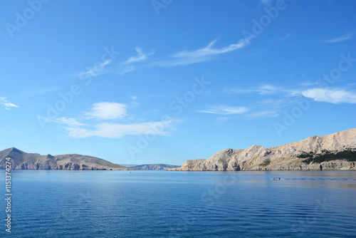 A serene scene of the Adriatic Sea with the islands of Prvic (left) and Sveti Grgur (in the middle) visible on the horizon (view from Krk island)
