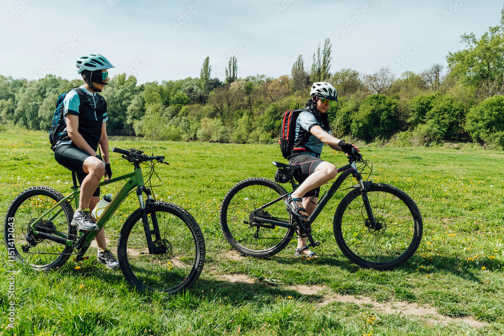 Friends with cycles at meadow on sunny day Friends with cycles at meadow on sunny day