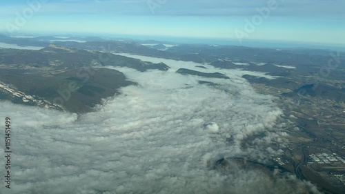 Wallpaper Mural POV flying over a valley covered by dense fog in a mountainous landscape. Aerial footage taken from an airplane cockpit in a left turn. 4K Torontodigital.ca