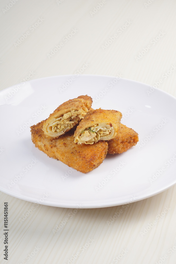 chicken rissoles enclosed in crepe-like wrappers and rolled into bread crumbs and fried. served on wood plate. perfect for recipe, article, catalogue, promotion, or any cooking contents. chicken rissoles enclosed in crepe-like wrappers and rolled into bread crumbs and fried. served on wood plate. perfect for recipe, article, catalogue, promotion, or any cooking contents.