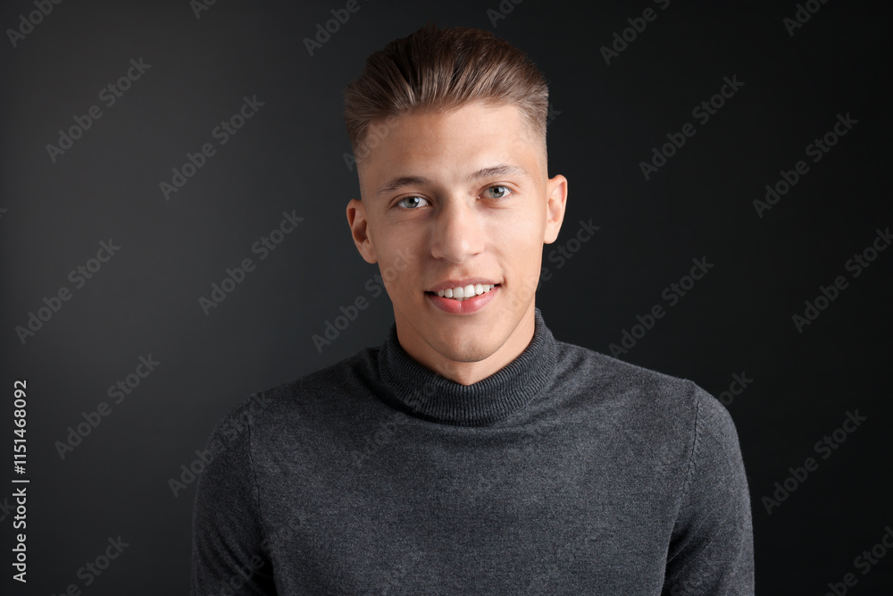 Obraz premium Handsome young man with stylish haircut on black background