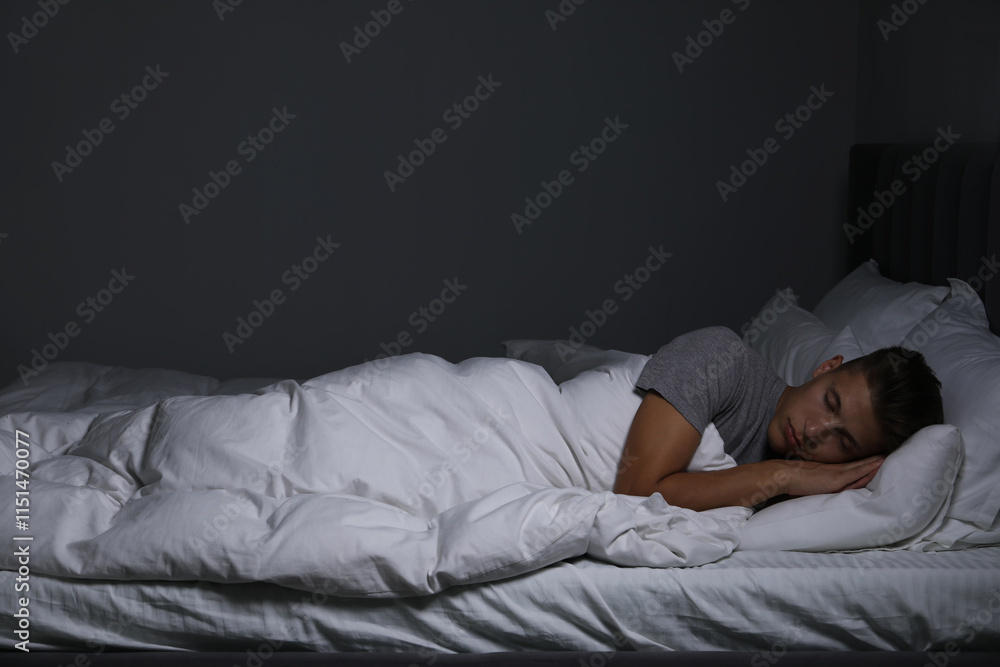 Young man sleeping in soft bed at night Young man sleeping in soft bed at night