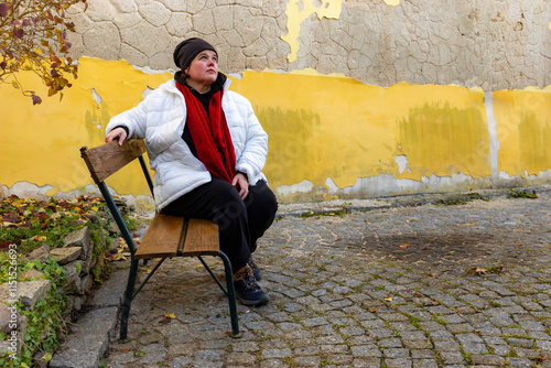 A plus-size woman strolling through the streets of a small European town.