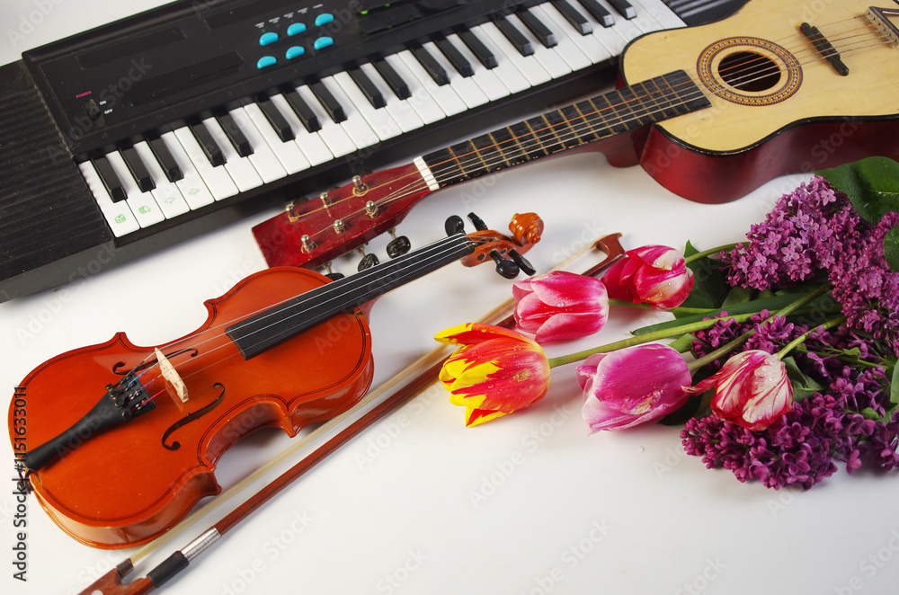 Naklejka premium Guitar, violin, synthesizer and a bouquet of tulips and lilacs.