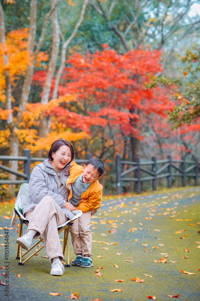 Fototapeta premium Chinese mother and her boy enjoying beautiful autumn foliage scenery of vibrant maple trees during December at Dujuan Valley in Xikou, Fenghua, Ningbo, Zhejiang, China