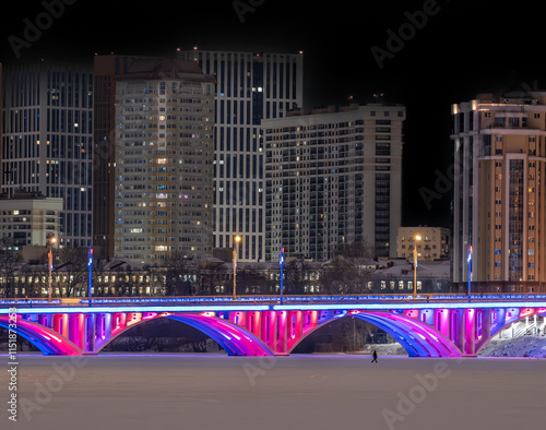 Photography A bridge with festive lighting in the city on a winter evening.