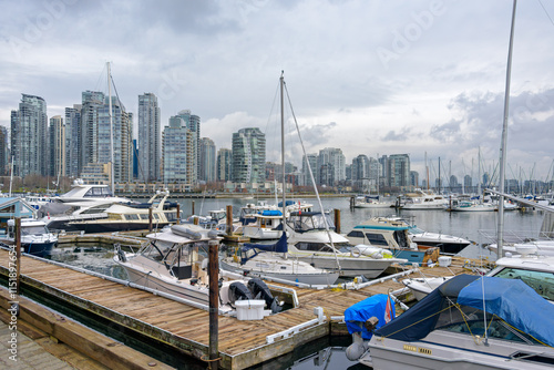 Yachts and boats moored at the pier in downtown of Vancouver, Canada photo