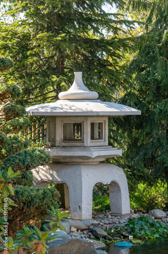 apanese garden in Galitskrgo park in Krasnodar Japanese garden lantern Yukimi-gata or “snow lantern” is squat lantern with wide roof. Lantern against backdrop of greenery of garden. photo