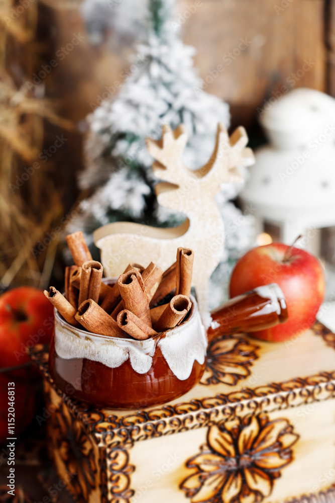 Classic Christmas home decoration with red apples and cinnamon sticks.