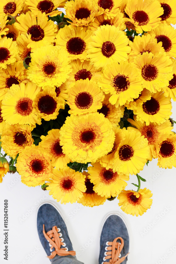 A person is standing by huge bouquet of sunflowers.