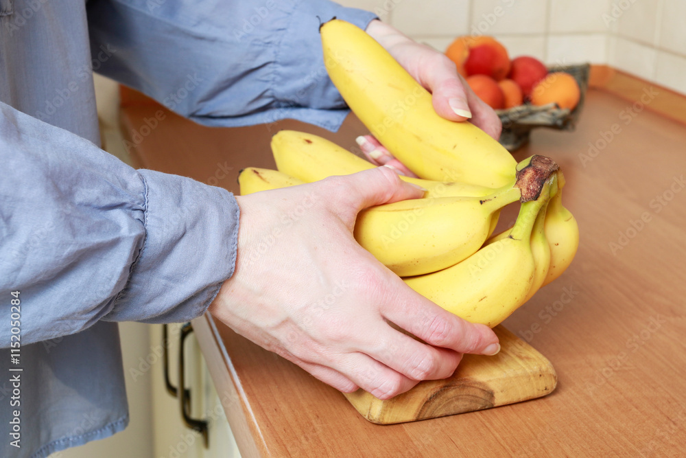 Young woman is holding bananas.