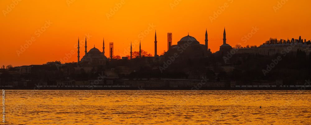 Eminonu city with mosque silhouettes in the background at sunset