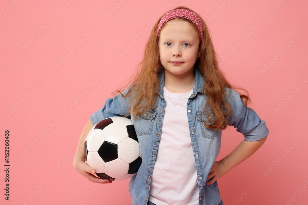 Little girl with soccer ball on pink background