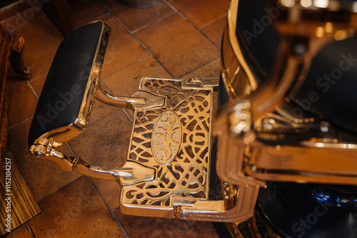 A barber chair with a gold foot rest