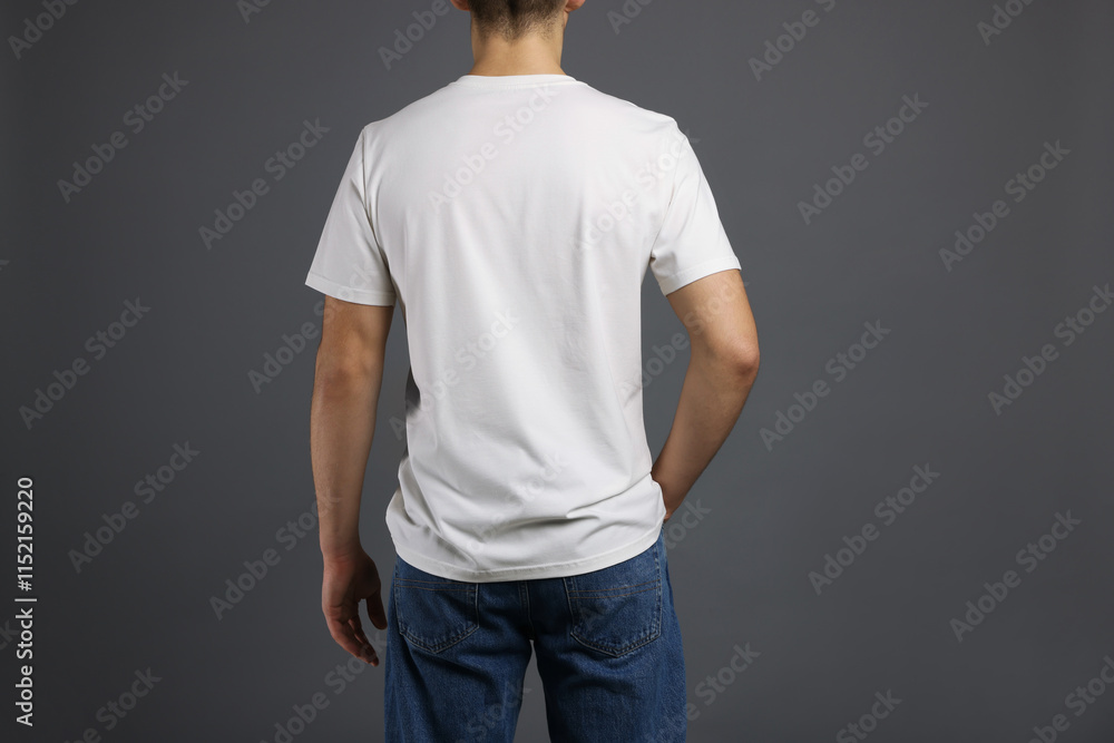 Obraz premium Man in stylish t-shirt on grey background, back view. Mockup for design