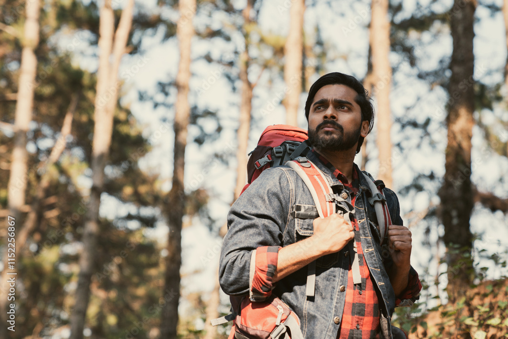 Obraz premium Travelers hiking through a forest with backpacks, exploring the wilderness and taking in the sights of nature as they walk.
