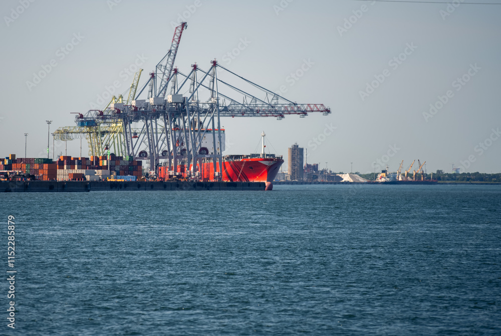 view of tall metal crane next to the water in summer against a clear sky on a sunny day view of tall metal crane next to the water in summer against a clear sky on a sunny day