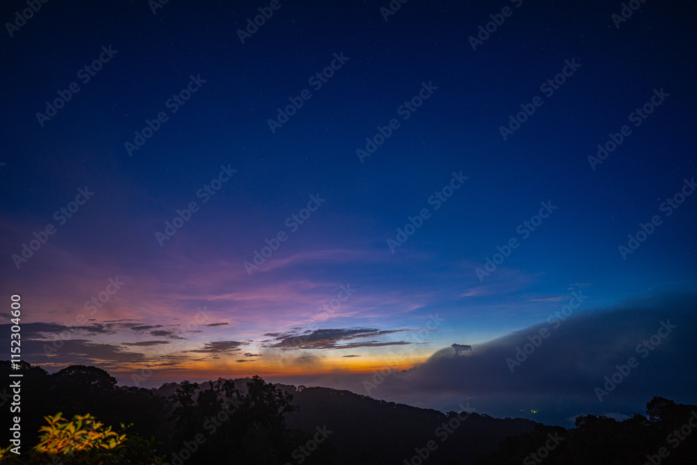 stunning mountainous landscape at sunrise with vibrant orange and pink hues illuminating the clouds against a blue sky. layer of mist settled in the valley, giving the scene a dreamy. stunning mountainous landscape at sunrise with vibrant orange and pink hues illuminating the clouds against a blue sky. layer of mist settled in the valley, giving the scene a dreamy.