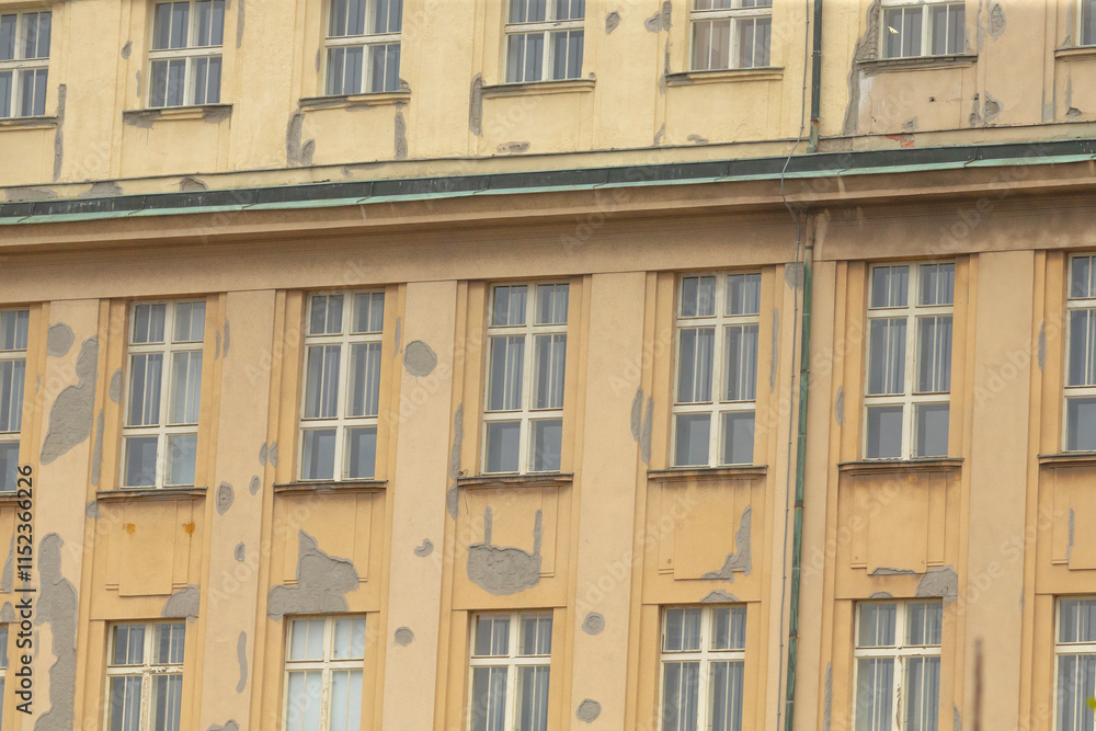 The weathered facade of a historic building showcases multiple windows set against a vibrant urban city background The weathered facade of a historic building showcases multiple windows set against a vibrant urban city background