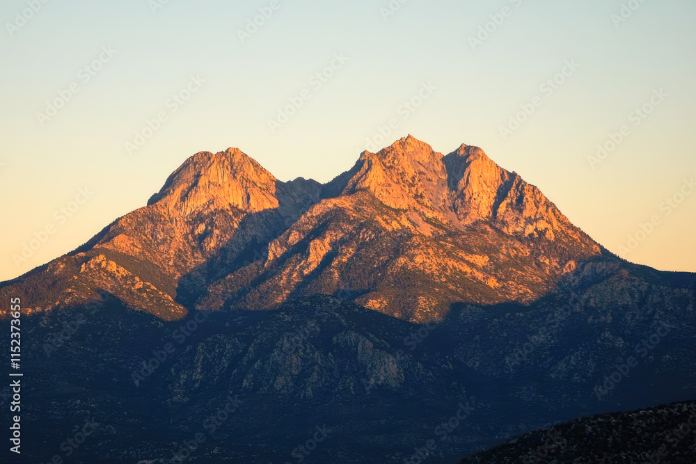 Fototapeta premium Majestic sunset over rugged mountain peaks in golden light