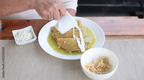 Woman adds cream cheese to enchiladas