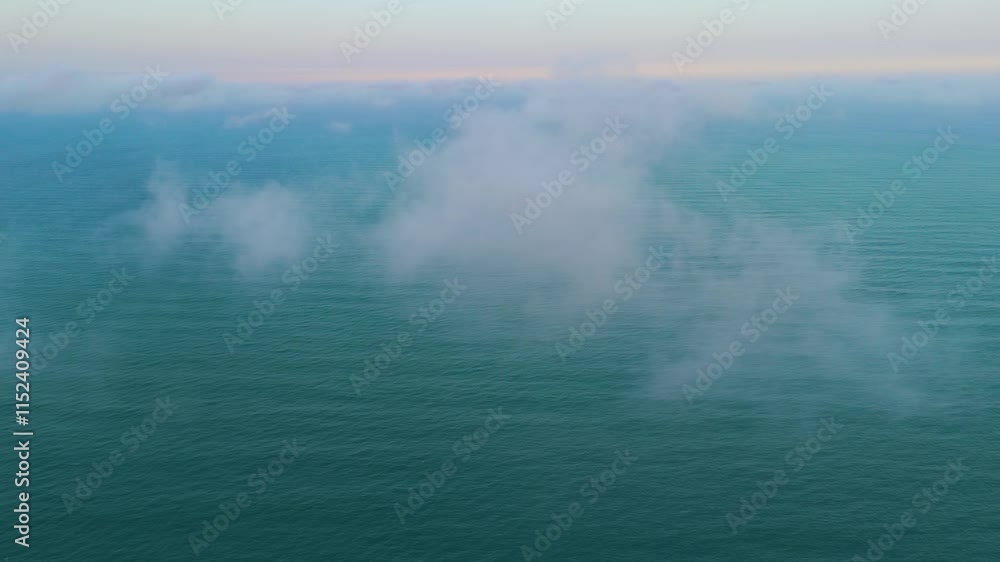 Beautiful shot crossing a thin, white cloud over the Gulf of Mexico. The turquoise waters of the sea merge with the warm colors of the horizon at sunset. Beautiful shot crossing a thin, white cloud over the Gulf of Mexico. The turquoise waters of the sea merge with the warm colors of the horizon at sunset.