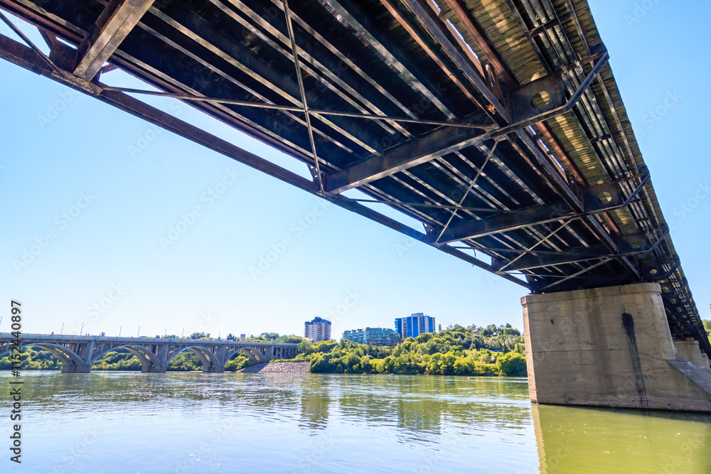 Obraz premium A bridge spans a river with a city in the background