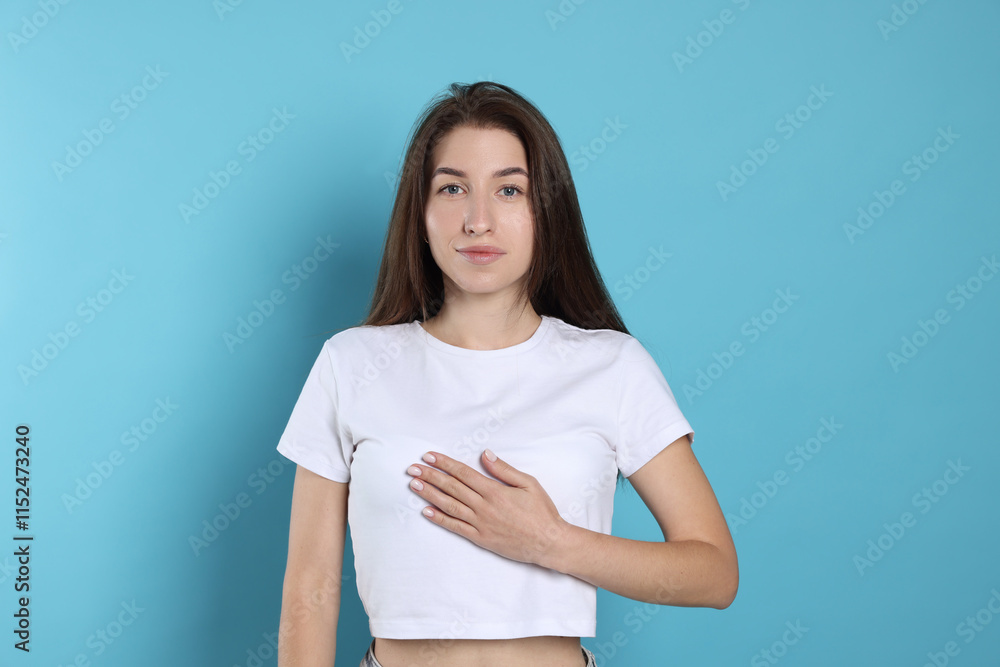 Woman making promise on light blue background. Oath gesture Woman making promise on light blue background. Oath gesture
