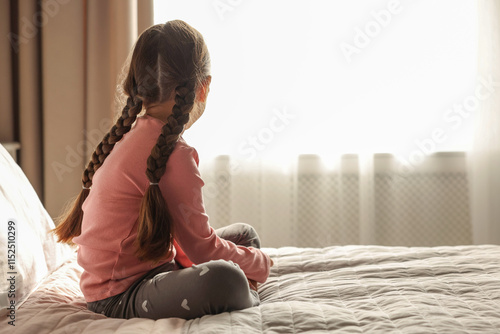 Canvastavla Orphanage concept. Girl on bed in room, back view