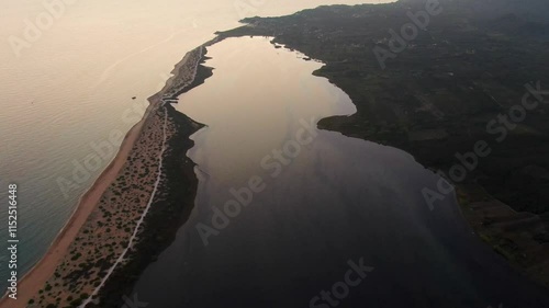 Aerial view of a sandy peninsula separating a calm lagoon from the ocean. photo